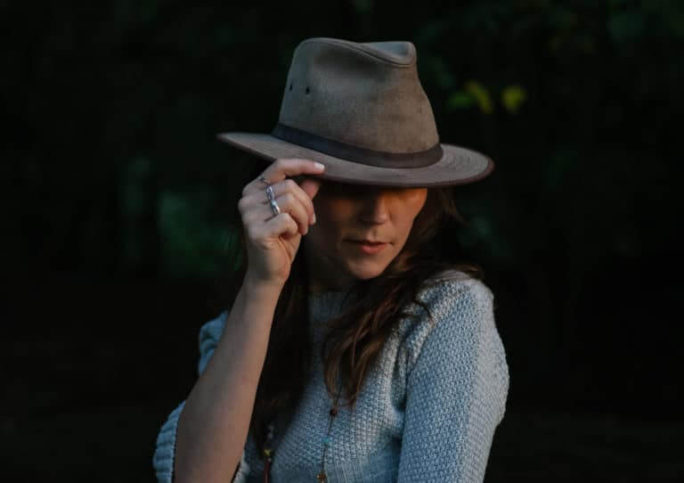 Lifestyle photo of a woman tilting her hat