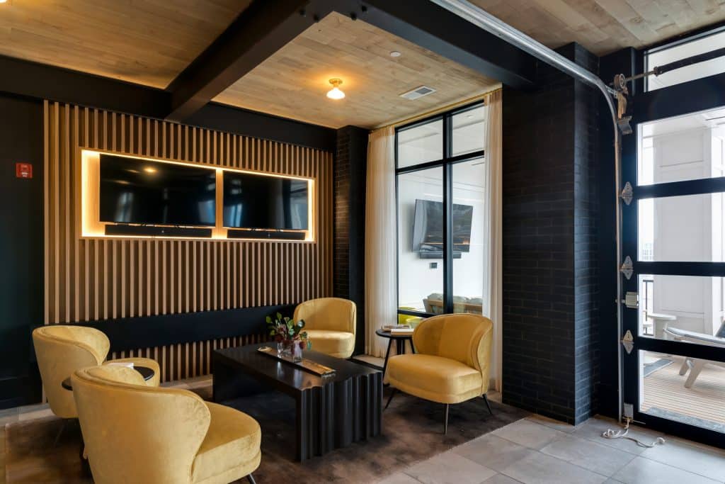 Modern seating next to TVs in community clubroom at Margaux Midtown