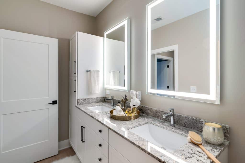 Double vanities and ample lighting around bathroom mirrors in homes at Margaux Midtown