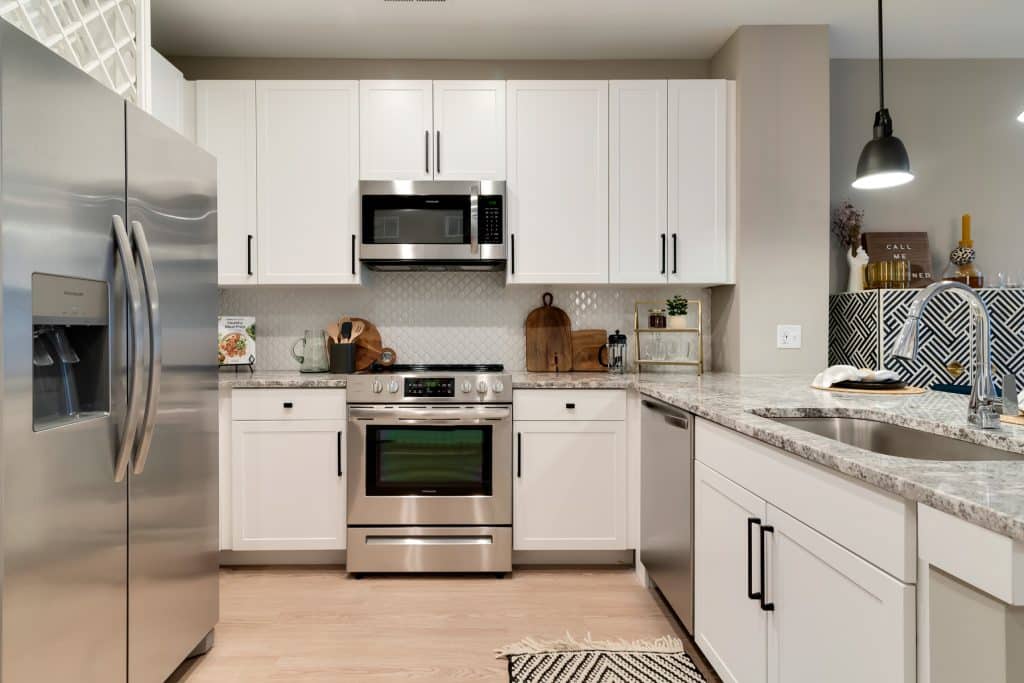 White cabinets and stainless steel appliances in apartment homes at Margaux Midtown