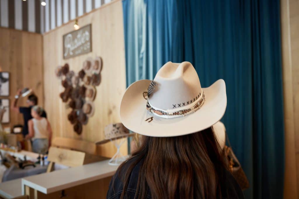 Woman walking around with Margaux Midtown branded hat