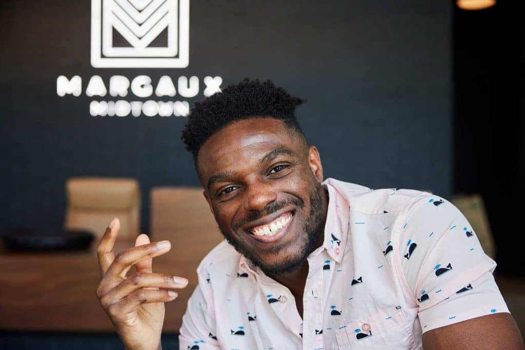 Resident smiling in front of Margaux Midtown sign