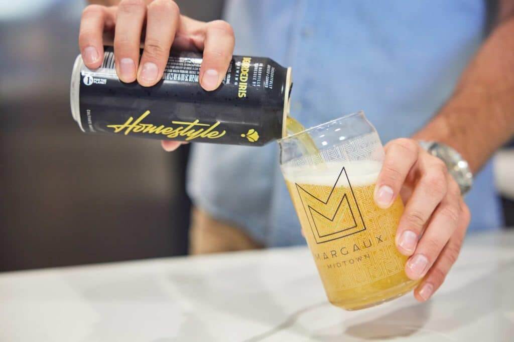 Resident pouring beer into a Margaux Midtown branded cup