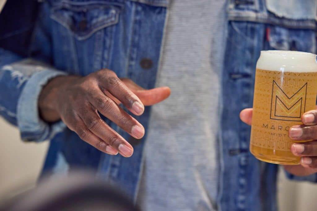 Resident holding beer in a Margaux Midtown branded cup