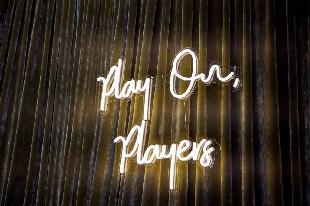 Margaux Midtown neon sign reading 'Play On Players'